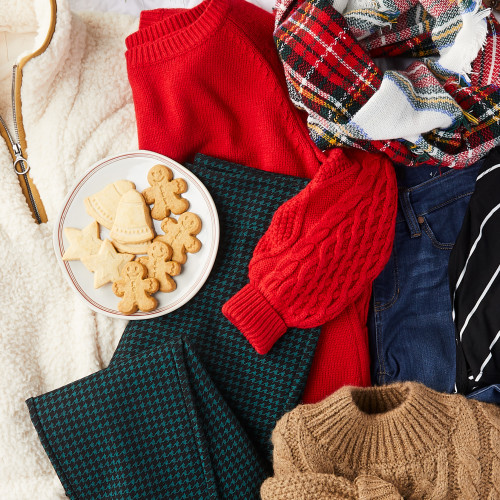 image of plaid pants, ivory quarter-zip sweater, red knit sweater, plaid scarf, jeans, and tan cable knit sweater laid out with plate of holiday sugar cookies 