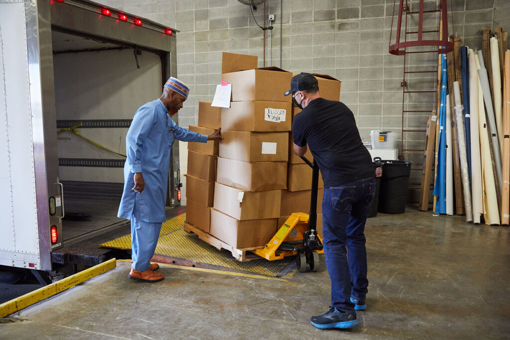 Men load a truck with boxes of Wantable clothing donations for Afghan refugees