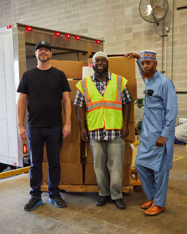 Three men at Wantable warehouse with a pallet of clothing donations for Afghan refugees