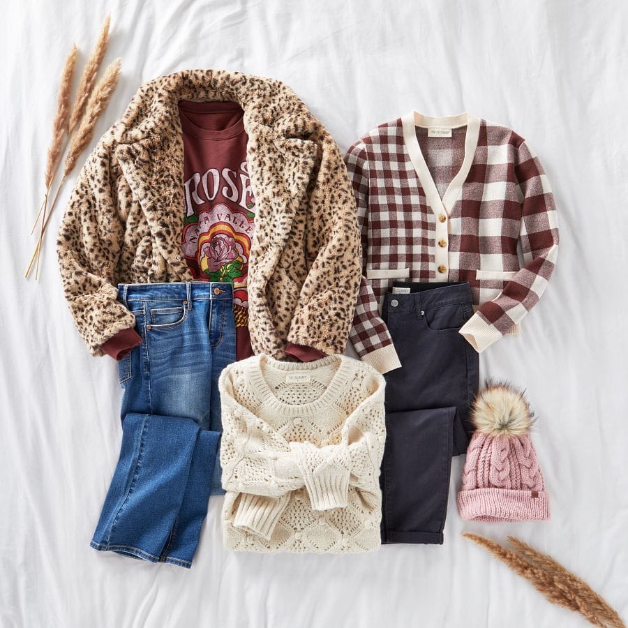 A faux fur leopard print jacket, graphic sweatshirt, plaid cardigan, straight leg jeans, pointelle sweater, colored jeans, and a cable knit pom beanie laid out in a fall setting.