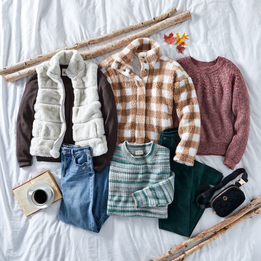 Faux vur vest, long sleeve top, plaid shacket, fair isle sweater, straight leg jeans, striped sweater, and colored jeans with a belt bag in a fall setting.