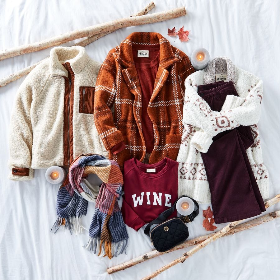 Sherpa shacket, plaid coatigan, aztec cardigan, colored pants, wine graphic sweatshirt, plaid scarf, and a belt bag laid out in a fall setting.