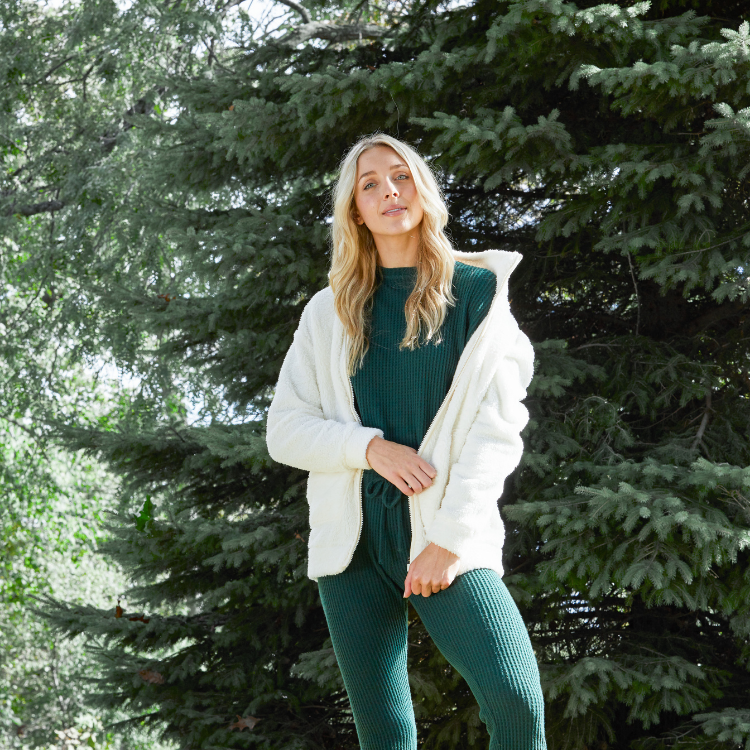 woman wearing a green workout set by trees - Christmas outfit from Wantable