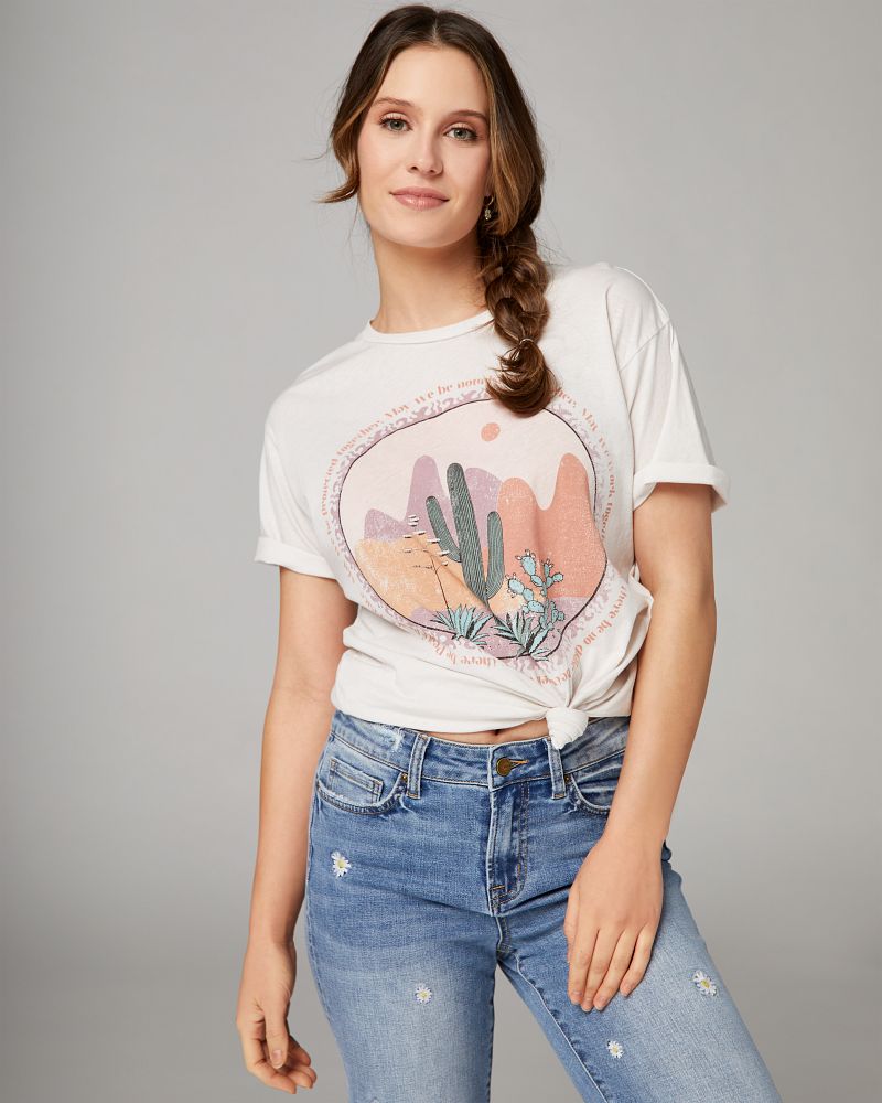 graphic t shirt tied in a knot paired with embroidered jeans.