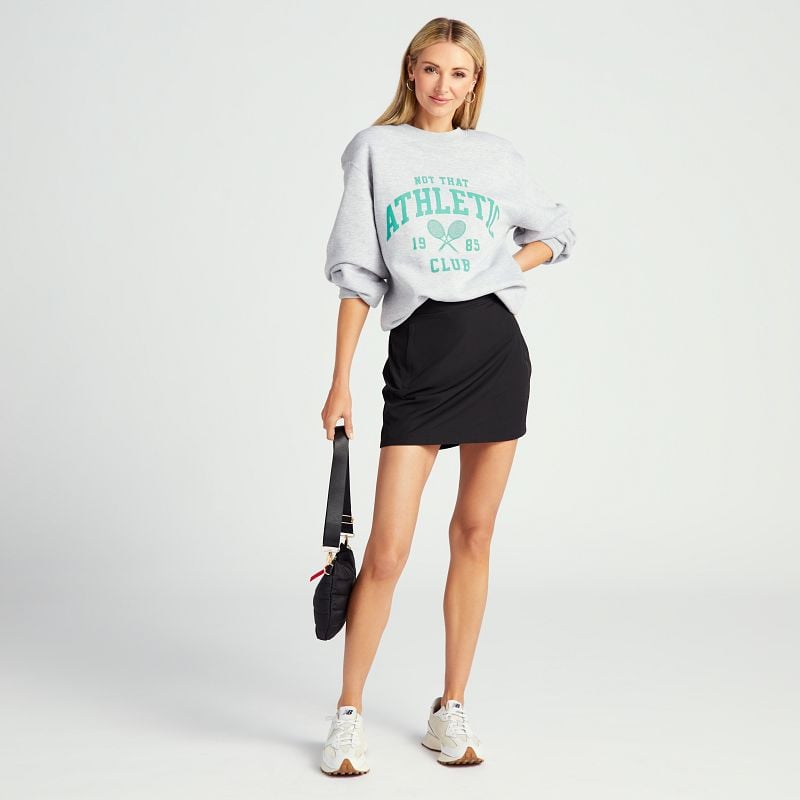 graphic sweatshirt layered over an athletic dress for an athleisure look