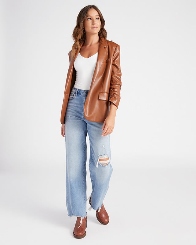 Brown leather blazer styled simply with jeans.