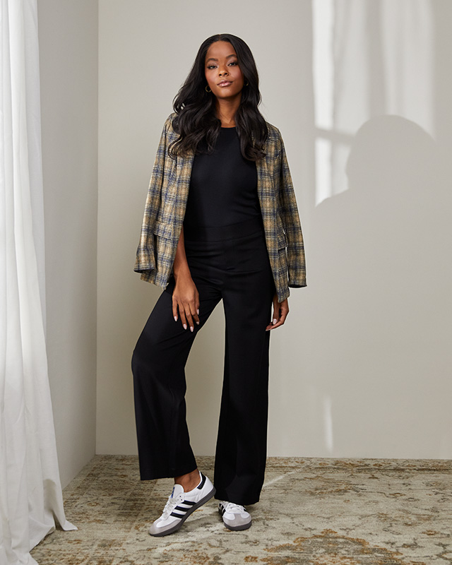 A boyfriend blazer in plaid styled with black trousers and sneakers.