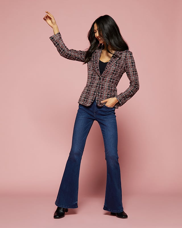 A pink, white, and black plaid blazer paired with simple flare jeans. A great answer to the question how to style a blazer.