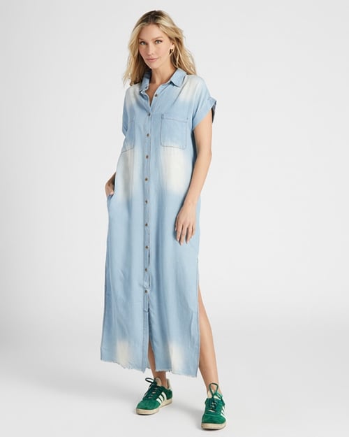 A full-body photo of a Wantable model wearing a denim shirt dress that is maxi length and features ombre detailing. 
