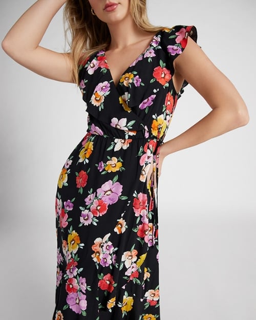 An up-close photo of a Wantable model wearing a black wrap dress with a bold floral print. 