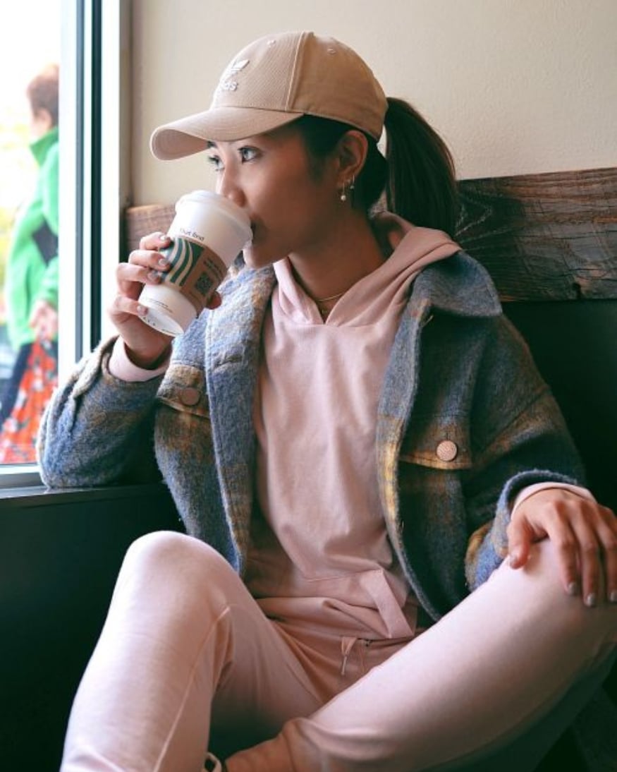 A Wantable influencer in a matching soft pink jogger set and hat. 
