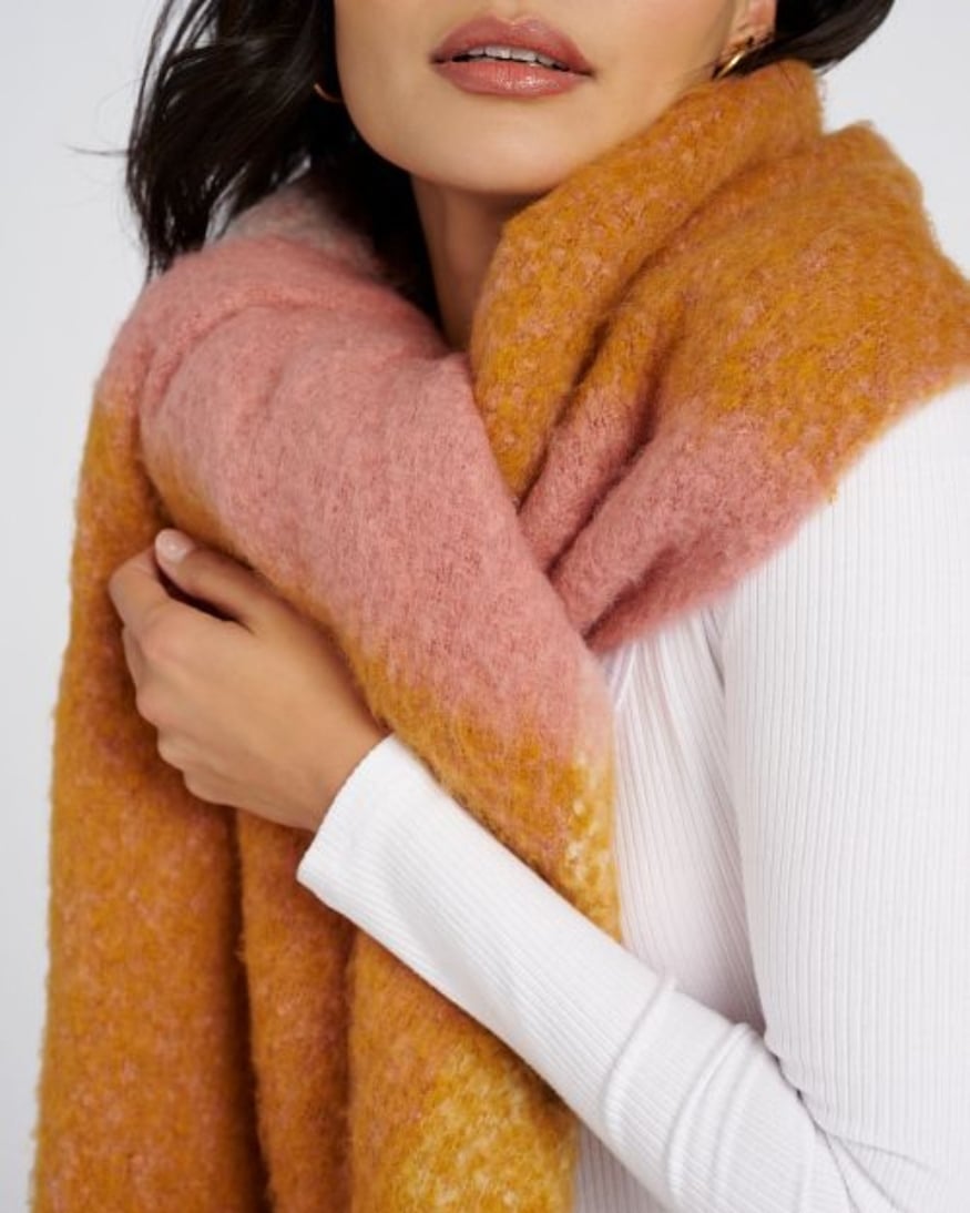 Model wearing a wool blanket scarf – the perfect accessory for your next flight. 