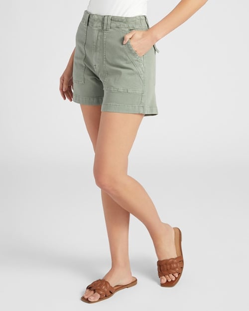 A photo of a Wantable model facing toward the camera to show off the front of a pair of high-waisted shorts. One of her hands is in her pocket. 