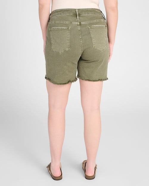 A photo of a Wantable model facing away from the camera to show the back of a pair of green denim Bermuda shorts. 
