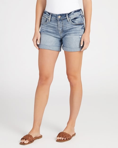 A photo of a Wantable model wearing a pair of cuffed denim boyfriend shorts and brown sandals. 