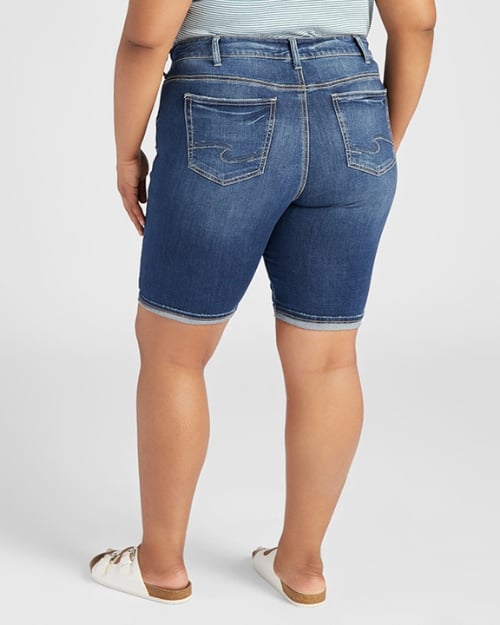 A photo of a Wantable model facing away from the camera to show the back of a pair of denim Bermuda shorts. 